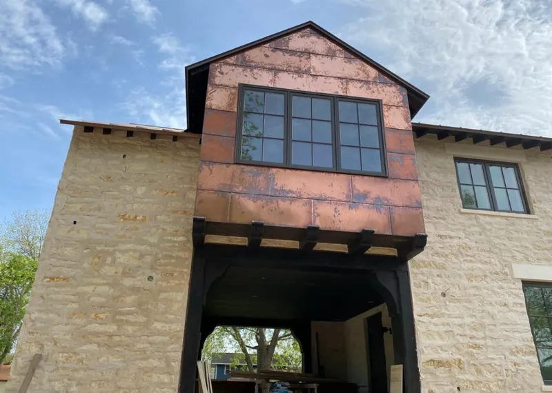 Copper metal panel facade on a stone building for Skylight Installation in Goshen